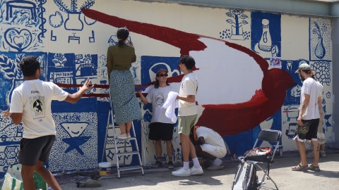 Estudiants pintant un murakl